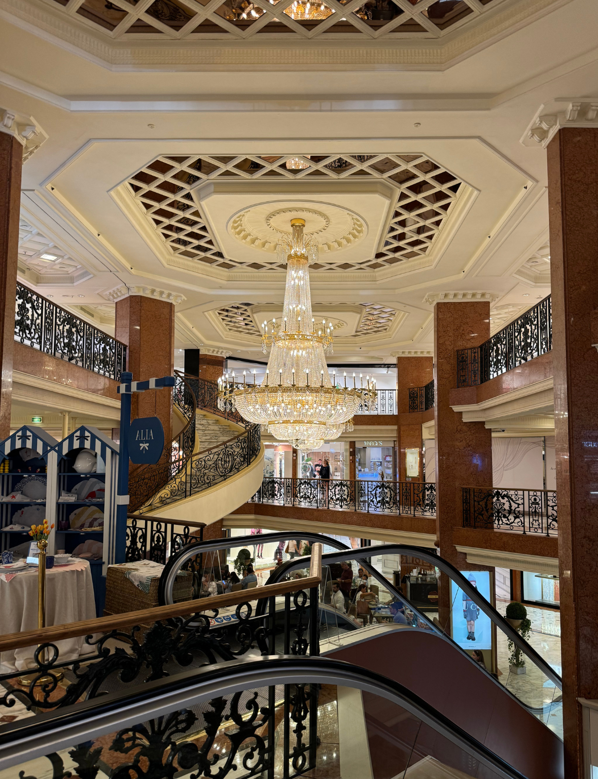Luxurious interior of a shopping mall with a chandelier and escalators inside Métropole in Monaco