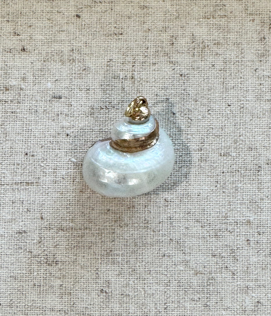 Small decorative item resembling a miniature tower on a textured beige background
