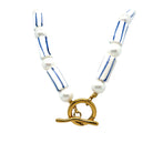 A striped blue and white bead and pearl necklace with a gold-tone loop and bead details.
