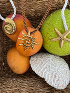 Decorative stones with starfish, shell, and sun design on a woven surface