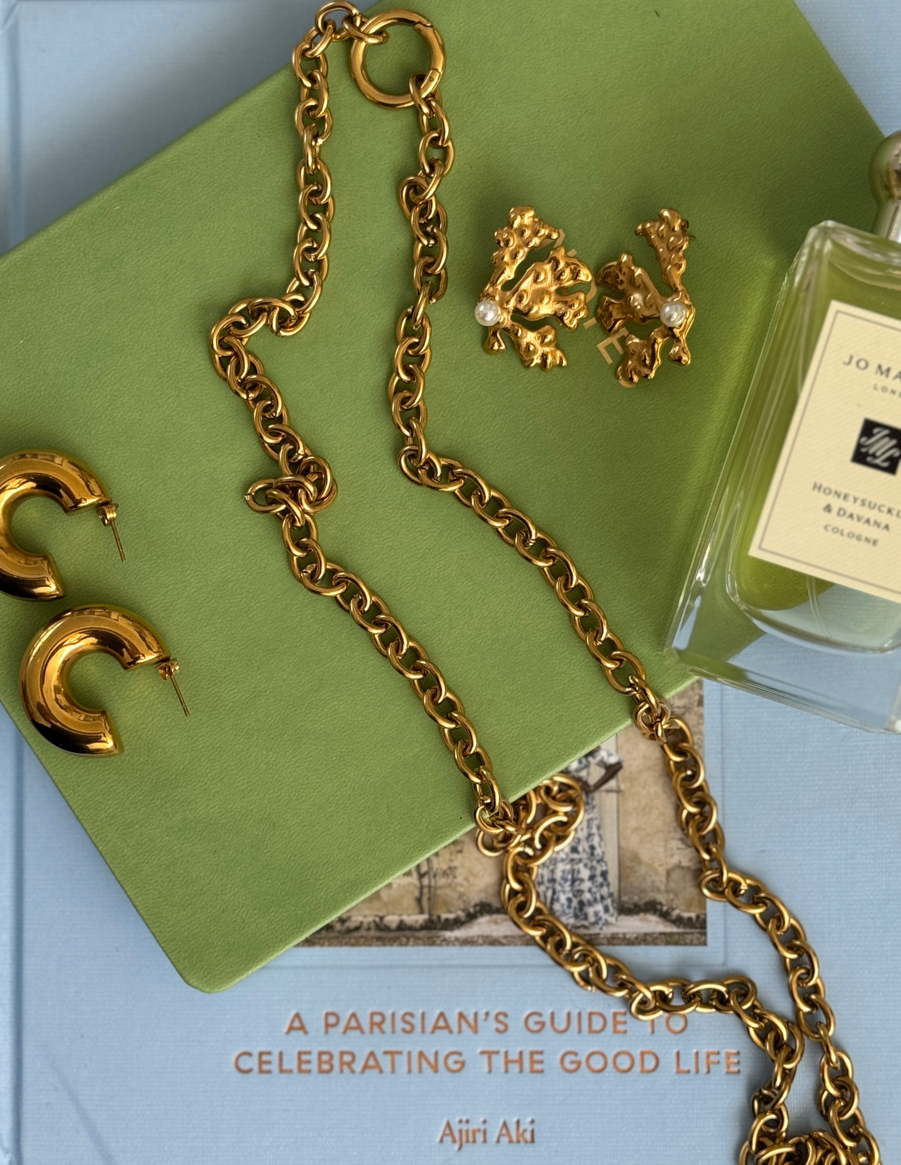 Gold necklace and gold earrings displayed.