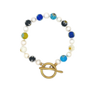 A beaded stretch bracelet featuring white faux pearls, blue and black marbled glass beads, a yellow-green marbled bead, and a gold-tone toggle clasp, shown on a plain white background.
