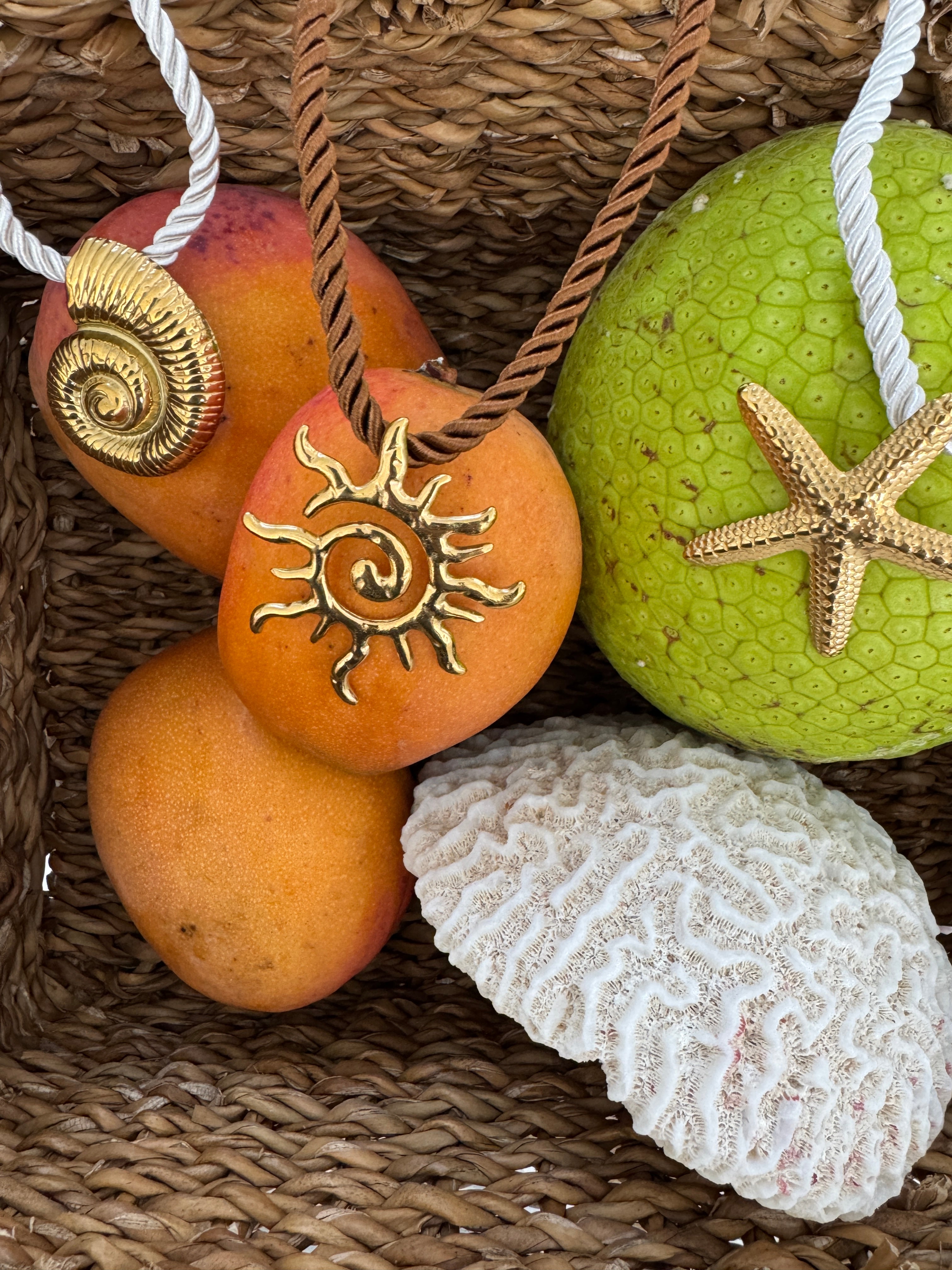 Decorative stones with starfish, shell, and sun design on a woven surface