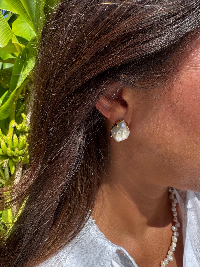 Bold yet refined, these baroque pearl studs feature lustrous, one-of-a-kind pearls cradled in delicate gold-tone claw settings. Each organic pearl is uniquely shaped, making every pair a wearable work of art. The contrast of fluid pearl and structured gold adds a modern edge to their timeless elegance — perfect for day-to-night sophistication.
