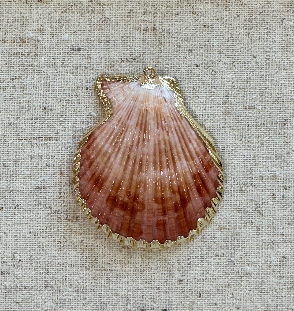 Shell pendant on a textured beige fabric background