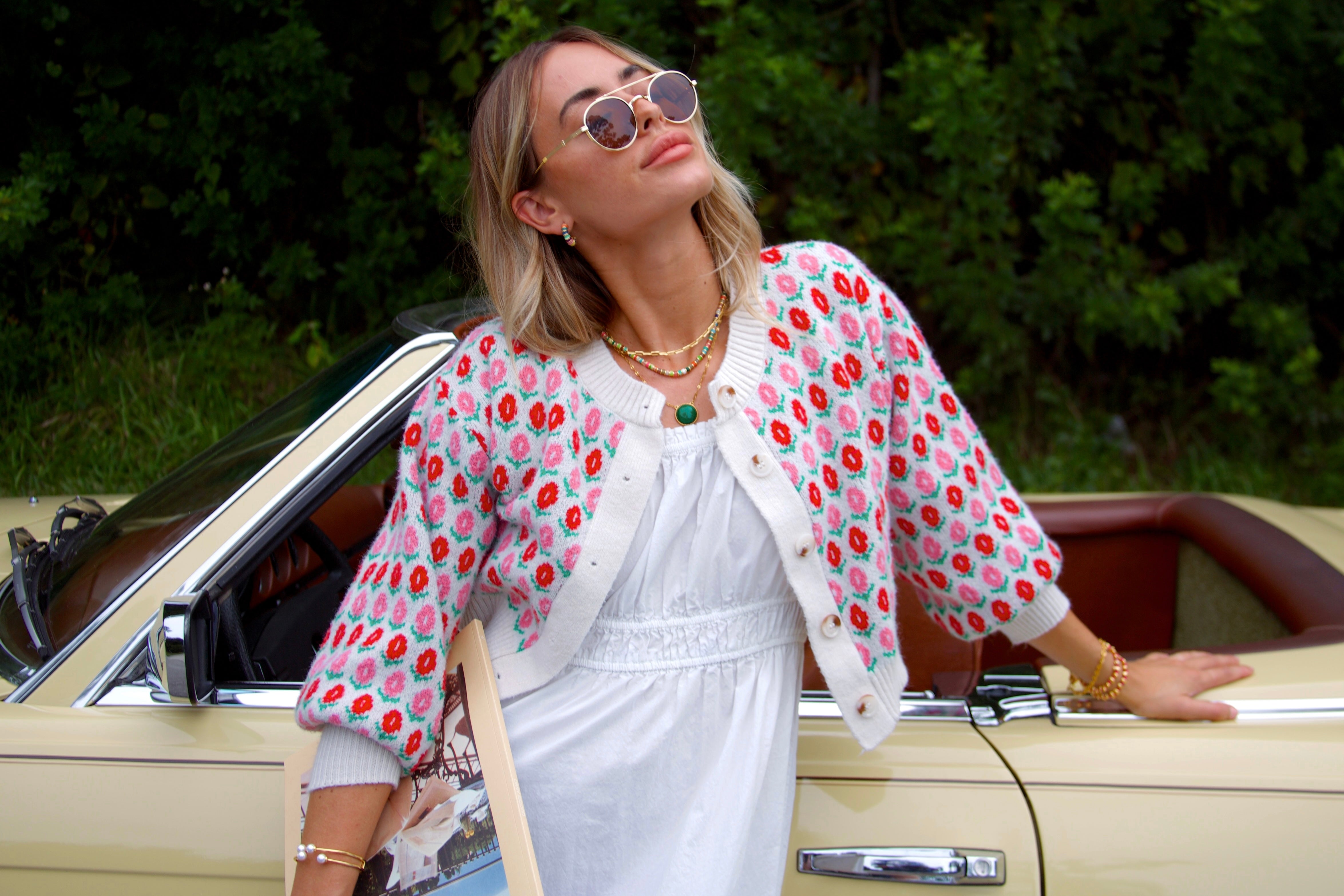 A simple statement piece to add a bit of glam to any curated necklace stack. Woman leaning on a yellow Mercedes