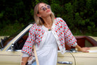 A simple statement piece to add a bit of glam to any curated necklace stack. Woman leaning on a yellow Mercedes